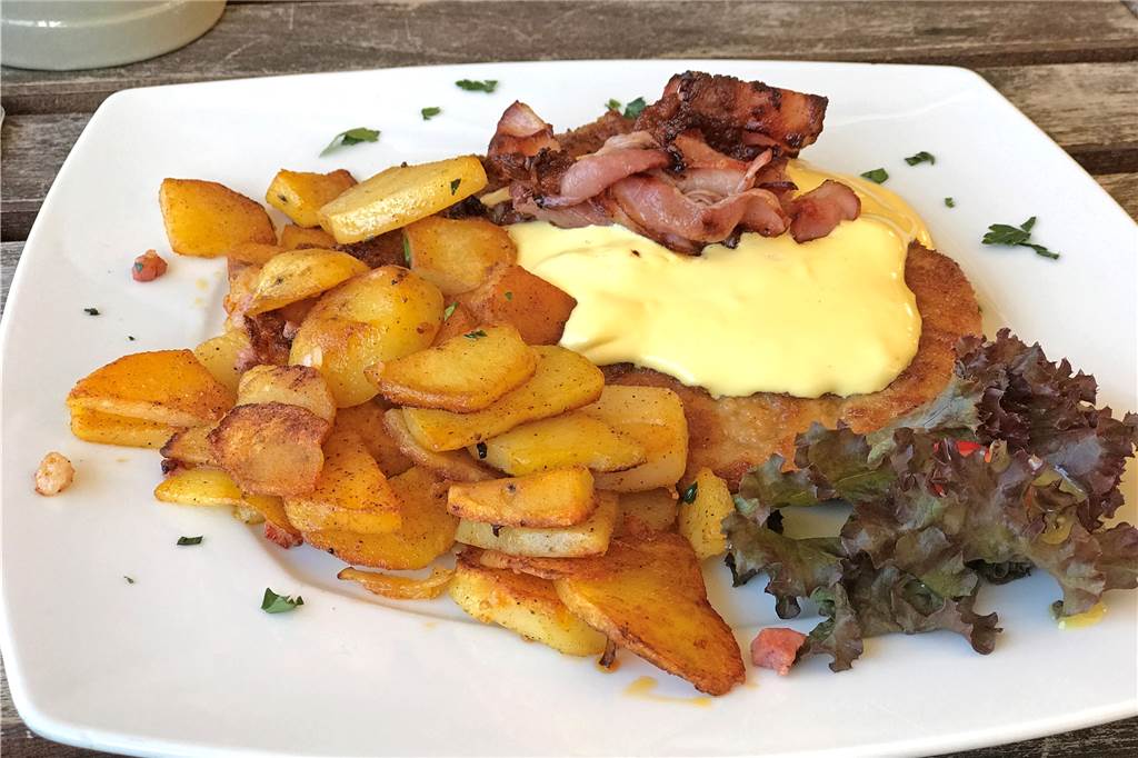 Warum das Brauhaus Rütershoff seinem Namen mehr als gerecht wird Die Hauptspeise meiner Begleitung: Ein Bergmann Schnitzel mit Sauce Hollaindaise, dazu Röstkartoffeln und Speckscheiben.