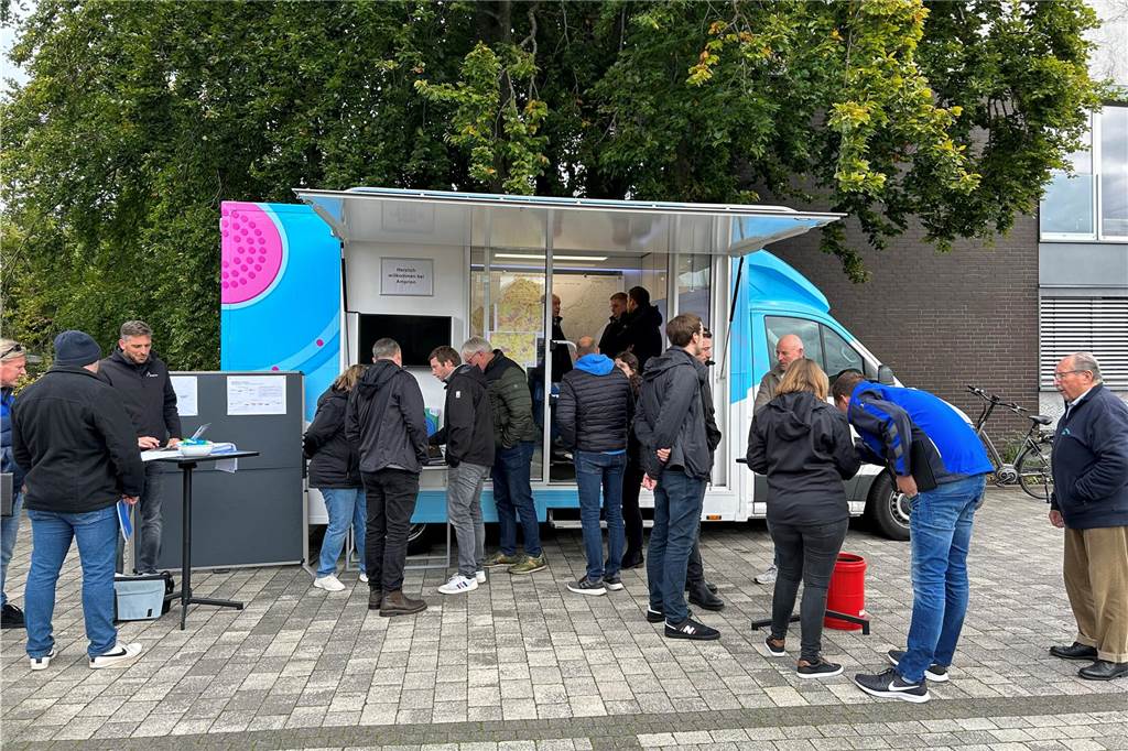Viele Menschen stehen um das Amprion-Infomobil in Heek herum