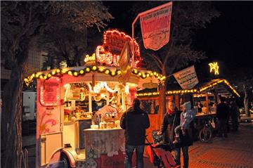 Die hell beleuchteten Buden auf dem Weihnachtsmarkt.