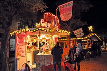 Die hell beleuchteten Buden auf dem Weihnachtsmarkt.
