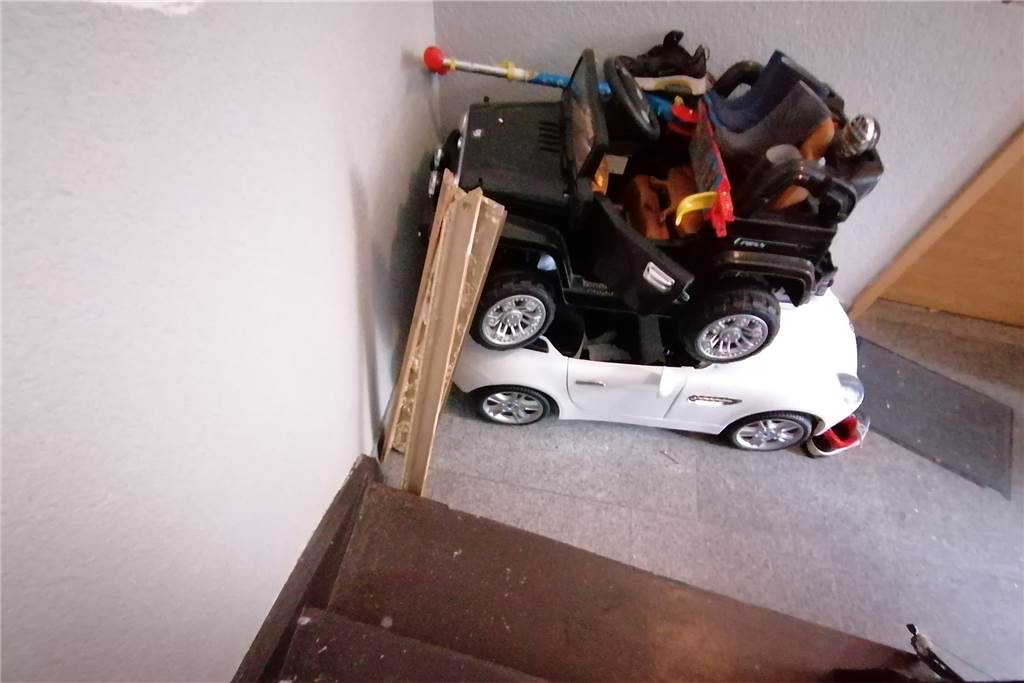 Tötungsdelikt in Dortmund: Panische Schreie reißen Nachbarn aus dem Schlaf Die herausgebrochene Türzarge lehnt an den Kinderautos. Neben der Tür stehen die Schue eines Sekundarschülers.