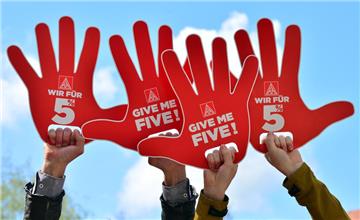 Die IG Metall fordert fünf Prozent mehr Geld für zwölf Monate. Während einer Kundgebung zeigen Metaller ihre Forderung auf stilisierten Händen mit der Aufschrift "Wir für 5 Prozent" und "Give me Five!", hier auf einem Archivbild aus Thüringen.