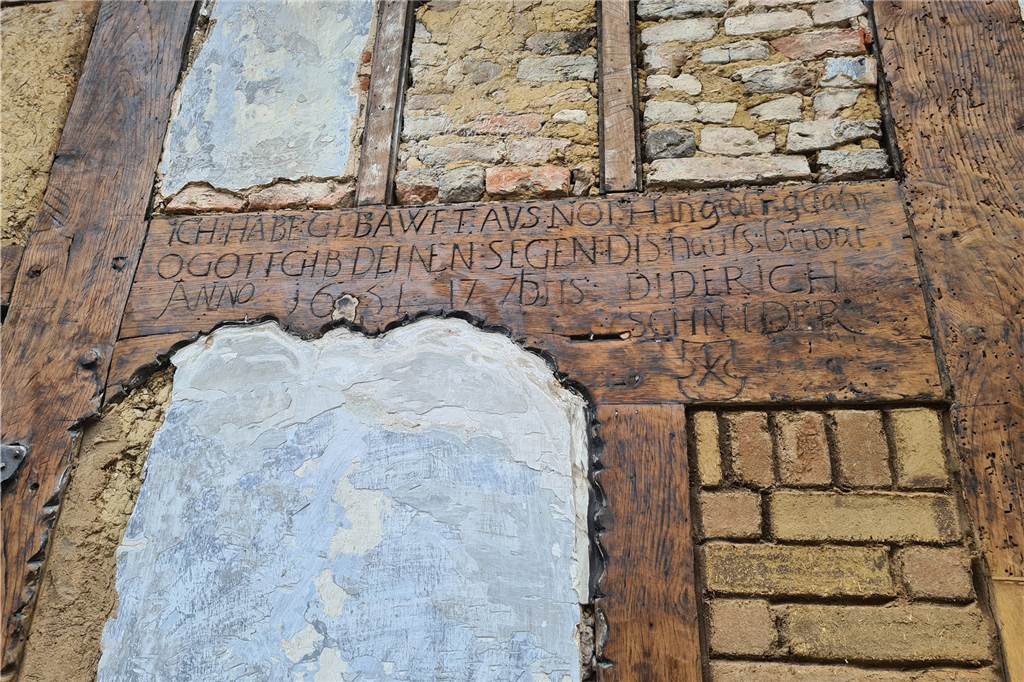Die Inschrift weist auf das Baujahr sowie auf den Erbauer des Hauses hin.