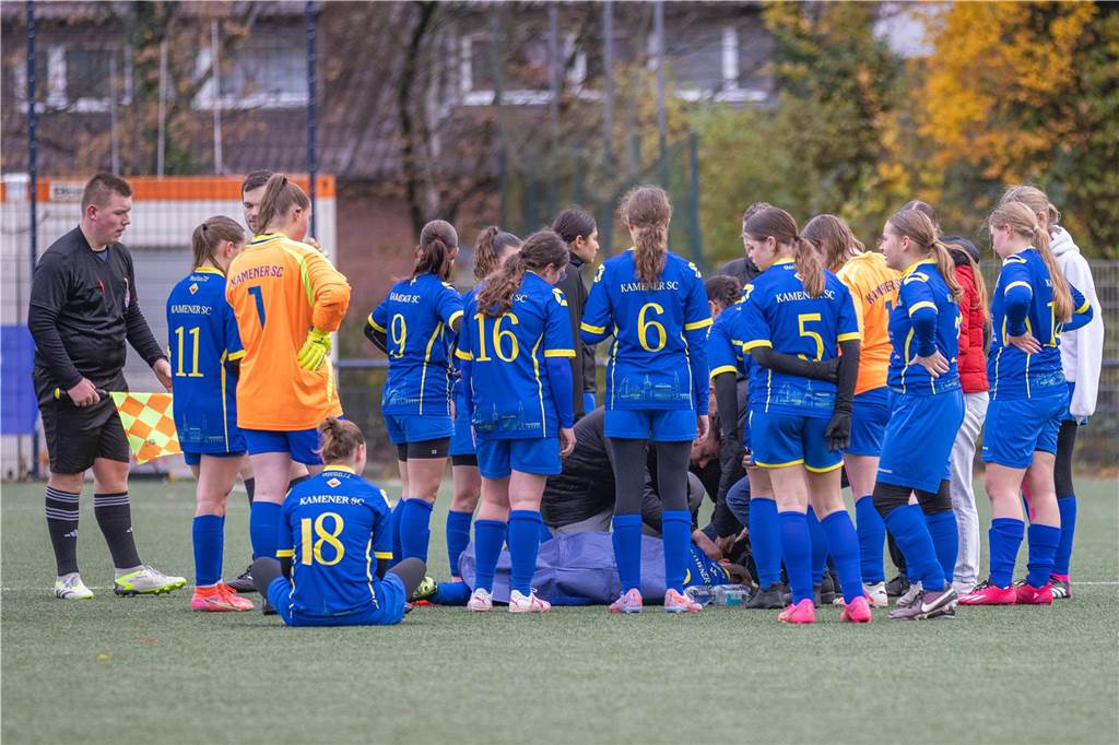 Kamener SC gibt Entwarnung bei ohnmächtiger Spielerin: Kehrt sie auf den Sportplatz zurück? Die Jugendspielerinnen des Kamener SC stehen um ihre bewusstlose Mitspielerin.