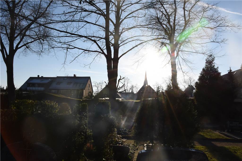 „Leichenzüge beeinträchtigen den Verkehr kaum:“ Wie sich der Umgang mit Tod verändert hat Die Kirchturmspitze der Ludgerikirche ist vom Friedhof aus zu sehen