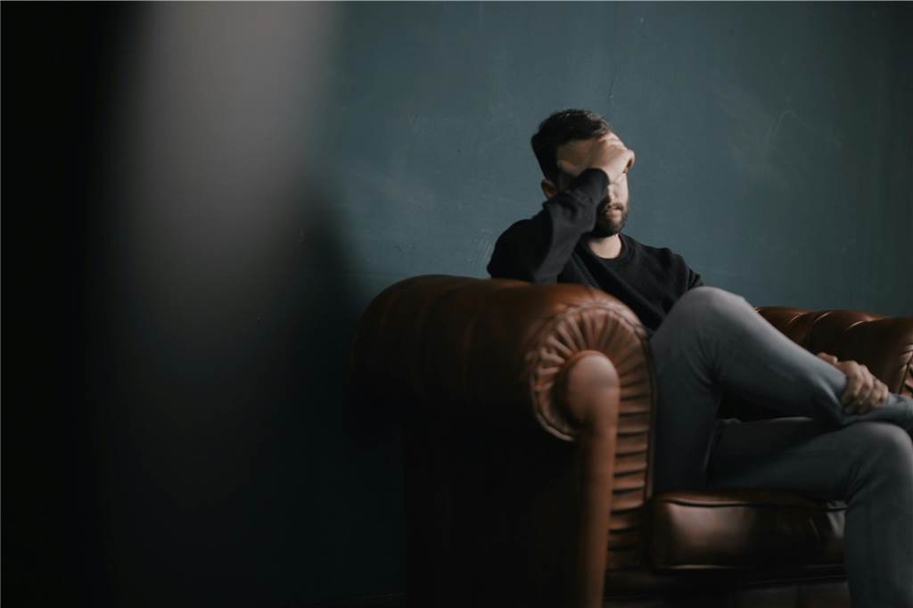Klaas (35) ist kokainabhängig: „Meine Sucht ist ein Beziehungskiller“ Ein junger Mann sitzt auf einer Couch und wirkt resigniert.