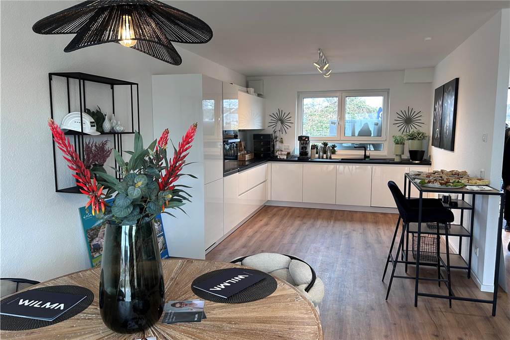 Musterhaus am Auenpark eröffnet: Das Highlight wartet im Dachgeschoss Die Küche im Untergeschoss ist bereits eingerichtet. An den Wohnraum schließen sich Terrasse und Garten an. Die unterste Etage ist offen gehalten und es grenzt der Wohnbereich an.