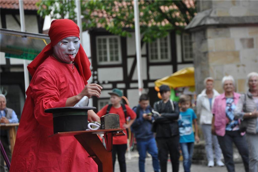 Straßenfestival in Werne 2024: Alle Infos auf einen Blick Ein Mann in roten Gewand zaubert auf der Bühne.