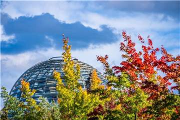Die Kuppel auf dem Deutschen Bundestag hinter bunt gefärbten Laubbäumen. In den kommenden Tagen finden zahlreiche Gespräche über die Bildung der künftigen Regierung statt.