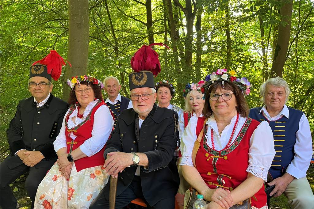 Die erste Wallfahrt zum Annaberg: Pilgerschaft hatte einen weiten Weg Auf dem Foto sind vier Männer und vier Frauen der Oberschlesier zu sehen. Sie tragen ihre Tracht und lachen in die Kamera. Im Hintergrund ist das Grün der Bäume zu sehen.
