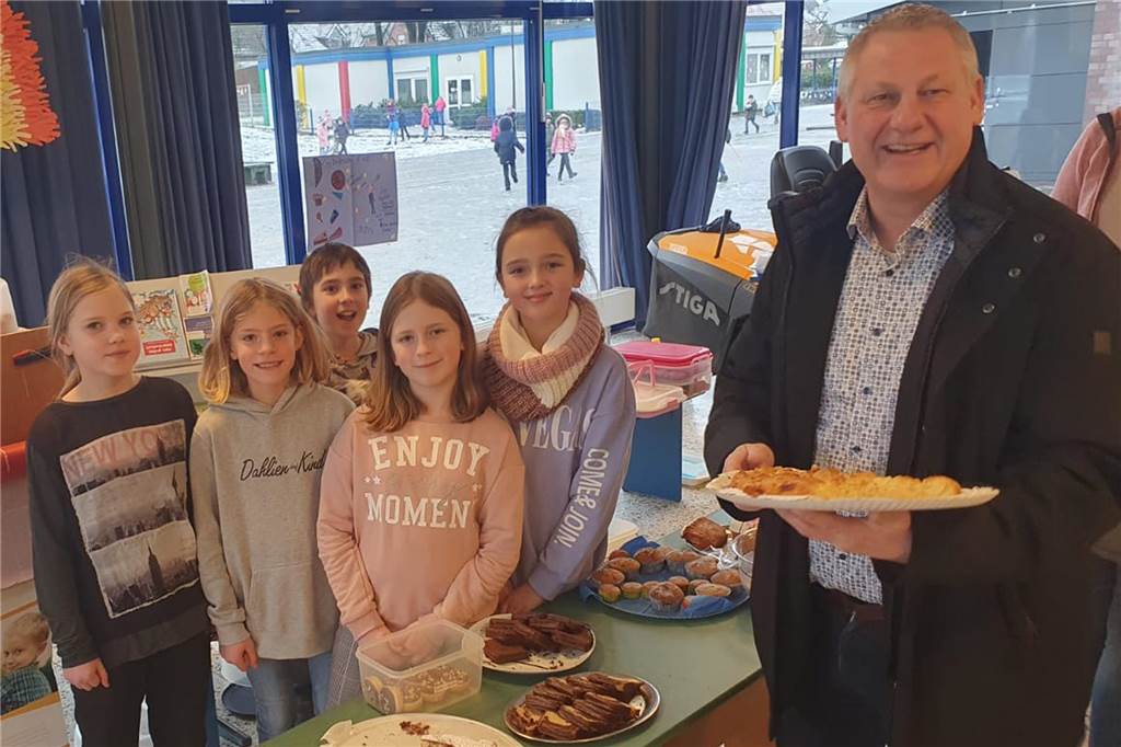 Bürgermeister Dieter Berkemeier kauft Kuchen in der Grundschule.