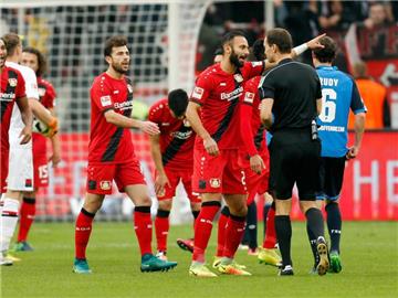 Die Leverkusener Spieler diskutieren mit Schiedsrichter Bastian Dankert. Foto: Ina Fassbender