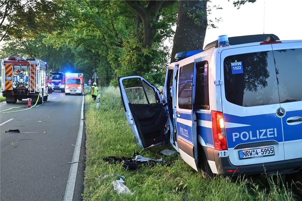 Zehn Monate nach Polizei-Unfall: Ermittlungen stocken, Staatsanwaltschaft irritiert Streifenwagen vor Baum, Feuerwehr und Rettungswagen auf der Straße