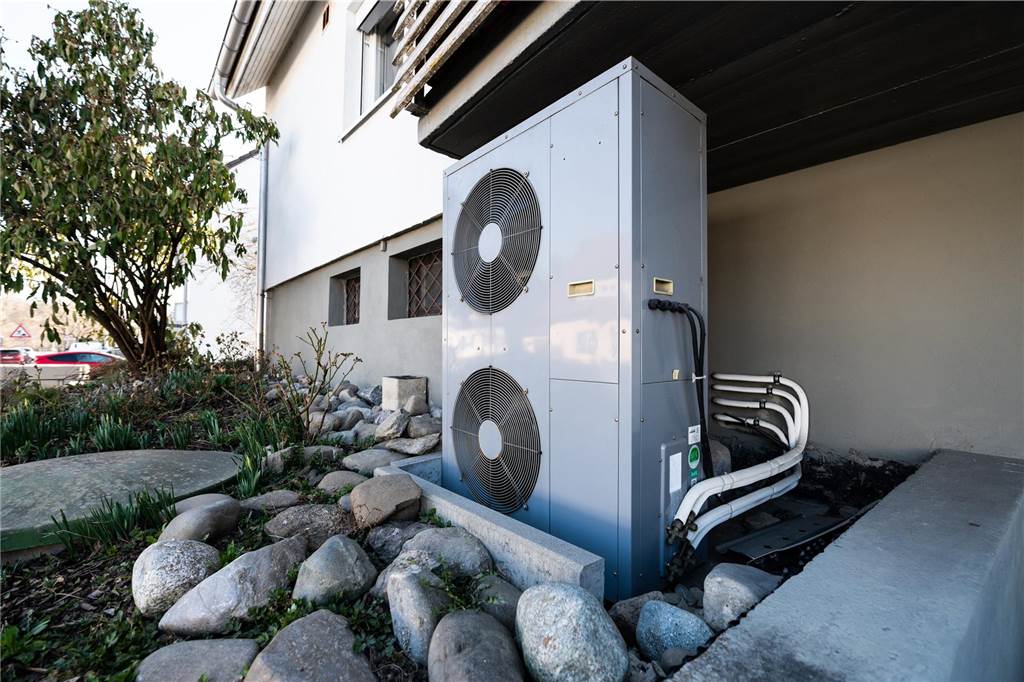 Gasheizung mit Wasserstoff? Das sagen Dorstener Heizungsbauer Die Lüftungsanlage einer Wärmepumpe steht vor einem Wohnhaus.