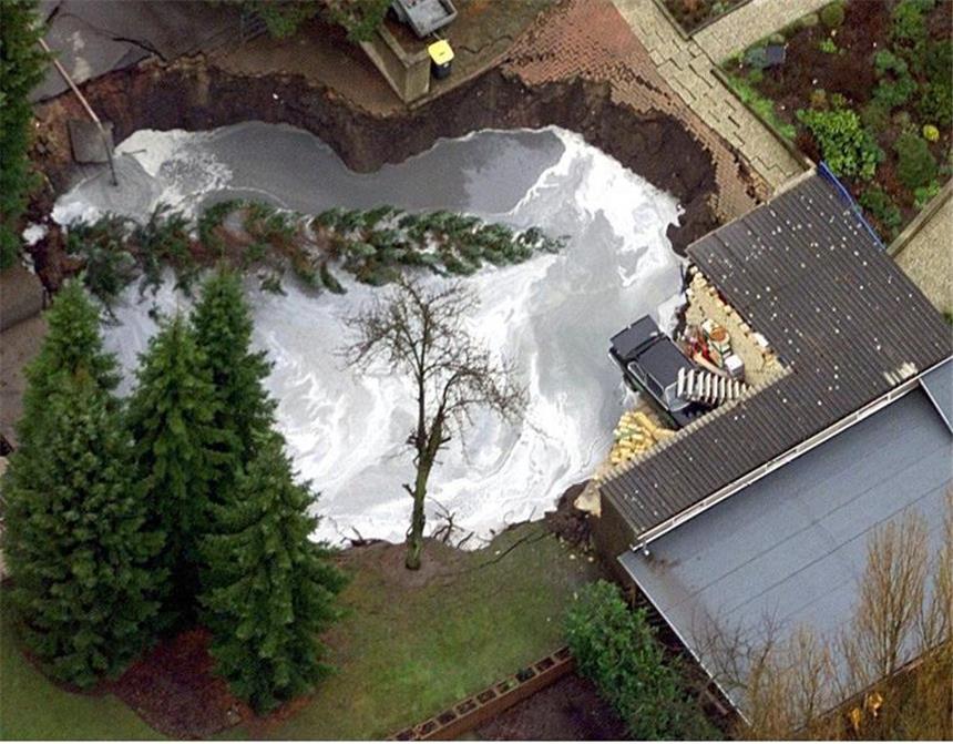 Vermächtnis aus der Tiefe: Wie NRW gegen Bergbau-Folgen kämpft Die Luftaufnahme vom 04.01.2000 zeigt das Wohngebiet in Bochum-Wattenscheid, in dem die Tagesbrüche auftauchten. Der größere Krater wurde zur Stabilisierung mit rund 1 500 Kubikmeter Beton gefüllt.