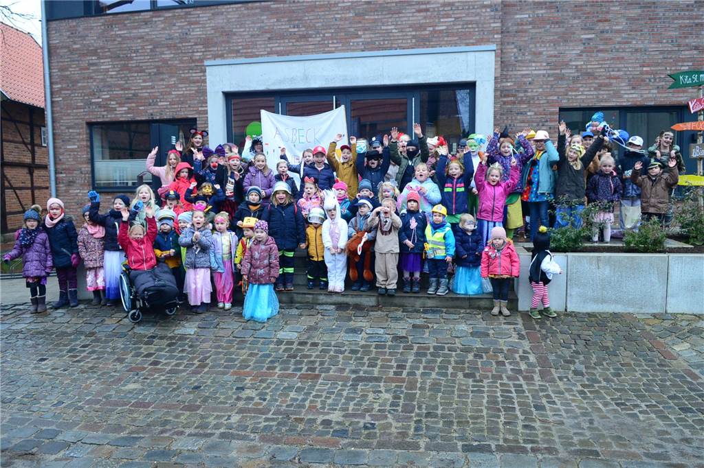 Die Kinder, die am Asbecker Kinderkarnevalsumzug teilnahmen, stehen vor dem Kindergarten.