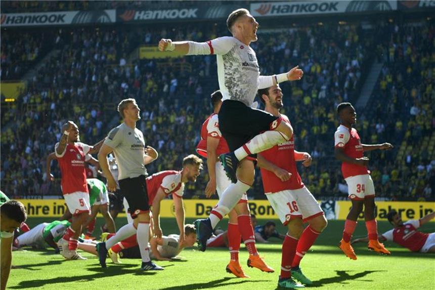 Lange Party mit Dortmunder Bier: Mainz feiert Rettung Die Mainzer Spieler bejubeln mit den mitgereisten Fans den Klassenerhalt. Foto: Ina Fassbender