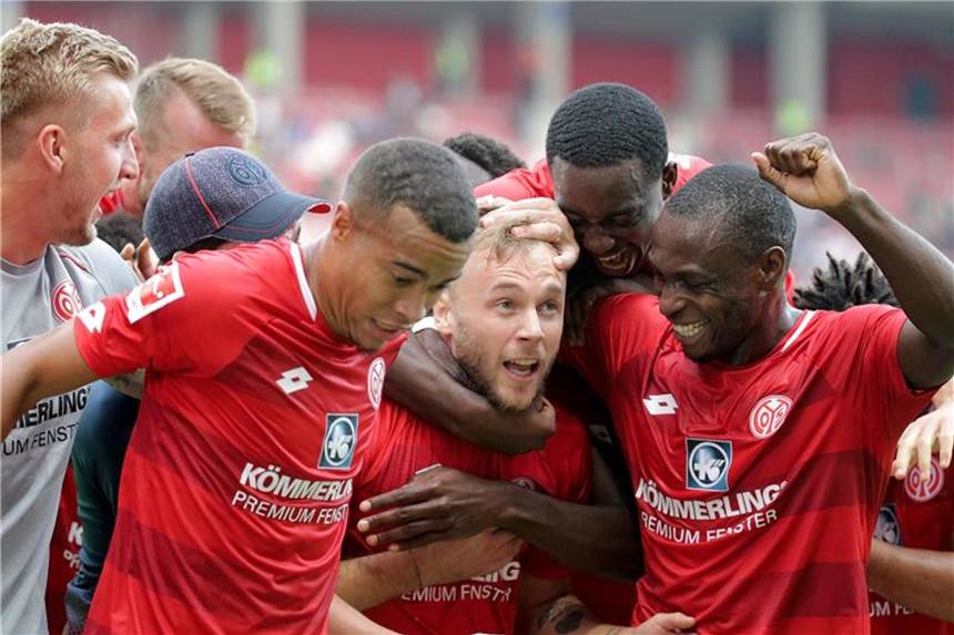 FSV Mainz bejubelt drittbesten Bundesligastart Die Mainzer Spieler bejubeln mit Trainer Sandro Schwarz (verdeckt mit der Mütze) den Sieg über den FC Augsburg. Foto: Hasan Bratic