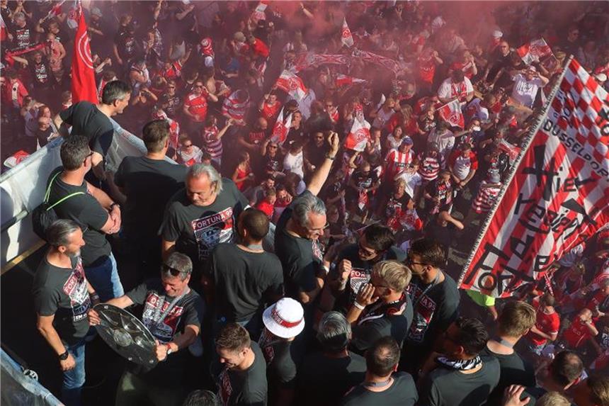 Rauschende Aufstiegsparty: Tausende Fans feiern Fortuna Die Mannschaft von Fortuna Düsseldorf jubelt auf dem Balkon am Rathaus mit ihren Fans im Hintergrund. Foto: David Young