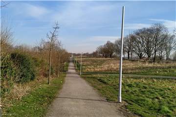 Die Masten stehen ohne Leuchten auf der Alten Fahrt in Olfen. Wirklich zum Einsatz kommt die beleuchtete Joggingstrecke wohl erst im kommenden Herbst.