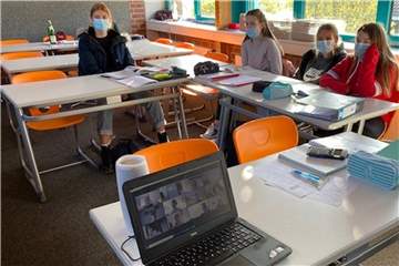 Die meisten Schüler sitzen im Klassenraum, doch einige Mitschüler sind "nur" virtuell dabei. Sie sind in Quarantäne, können aber dennoch am Unterricht teilnehmen.