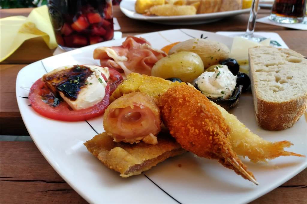Die meisten Tapas-Gerichte aus der Karte sind auch am Büfett zu finden: Wir probieren unter anderem Schinken, Manchego Käse, Oliven, Pilze, Salzkartoffeln mit roter Soße, Tomaten mit Mozzarella und Krebsfleisch-Kroketten.