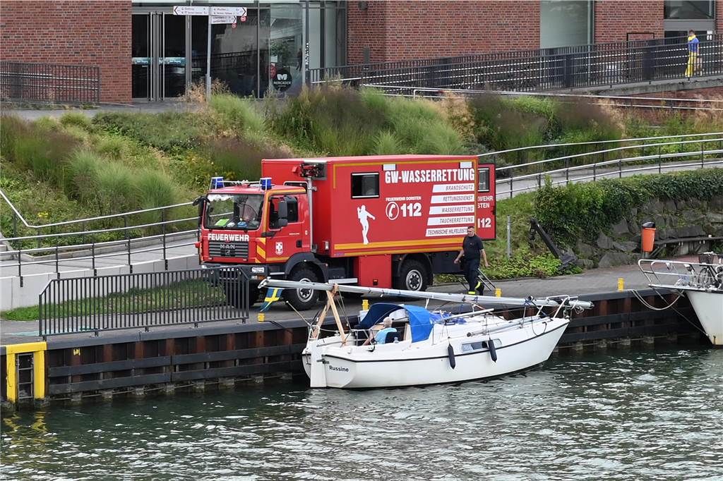 Schwedisches Ehepaar strandet: Taucher helfen Reisenden aus der Patsche Das Fahrzeug der Wasserrettung der Dorstener Feuerwehr steht an den Mercaden am Ufer des Wesel-Datteln-Kanals. Im Vordergrund liegt ein kleines Segelboot im Wasser.