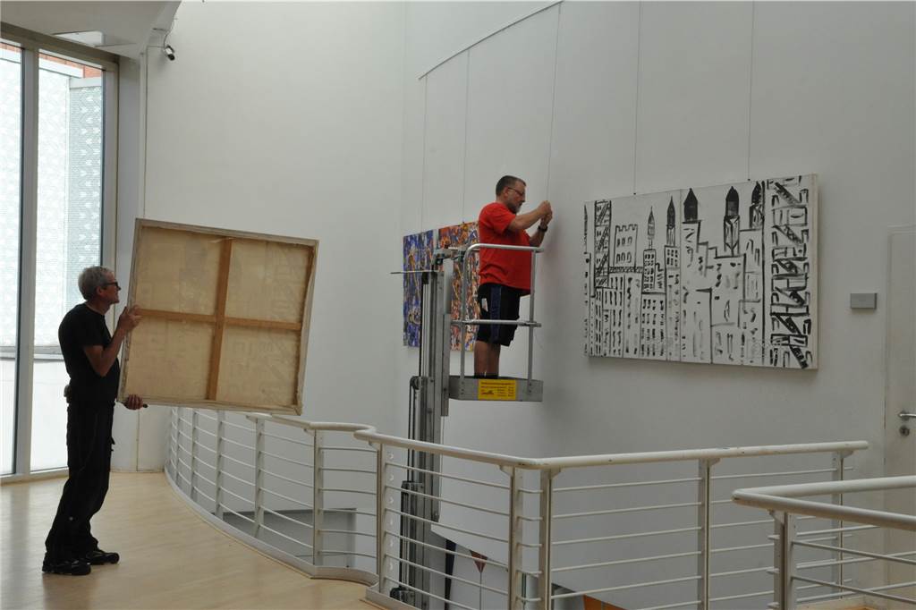 Beuys-Schüler Pascal Faber: Farbenfrohe Bilder aus verschiedenen Blickwinkeln Die Mitarbeiter der Bühnentechnik brachten am Donnerstag Bilder von Pascal Faber an den Wänden der Stadtgalerie im Hansesaal an.