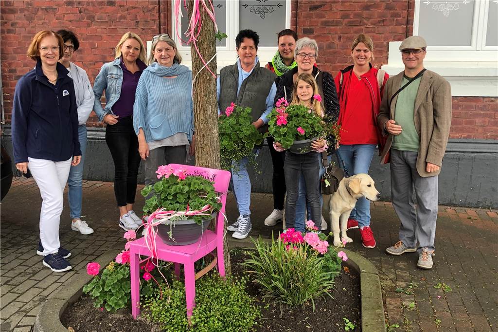 Selmer Altstadt: Was steckt hinter den rosa Blumen und Stühlen? Die Mitglieder der Werbegemeinschaft Selm haben sich gemeinschaftlich die Aktion einfallen lassen. Hier im Bild: Daniela Wehmeyer von der Altstadt Apotheke, Petra Lonnemann von Schreiben und Schenken, Eugenia Leicht von der Bären Apotheke, Lisa Sandmann von Spielen und Träumen, Michaela König von My Home, mehrere Vertreterinnen der Mobilen Pflegestube und Oliver Hübner von Blogwerk.