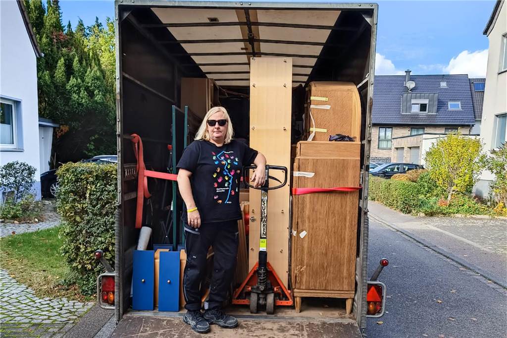 Claudia Großer steht vor Transporter mit Sachgütern