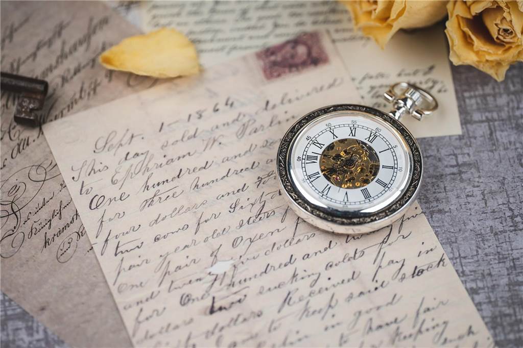 Eine Taschenuhr liegt auf einem alten Brief.