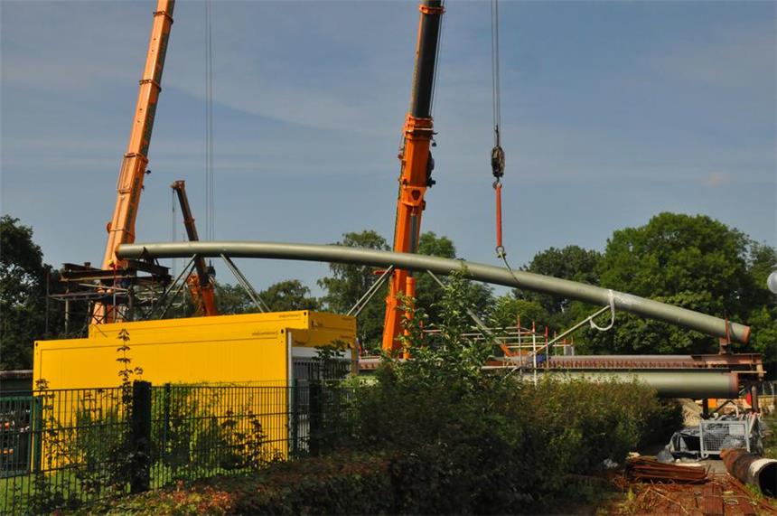 Seit Freitag laufen die Arbeiten an der Lippebrücke Die Montagearbeiten für die Brückenbögen Lippebrücke Graf-Adolf-Straße haben heute Morgen planmäßig begonnen. Das erste Bogenelement hängt bereits am Haken.