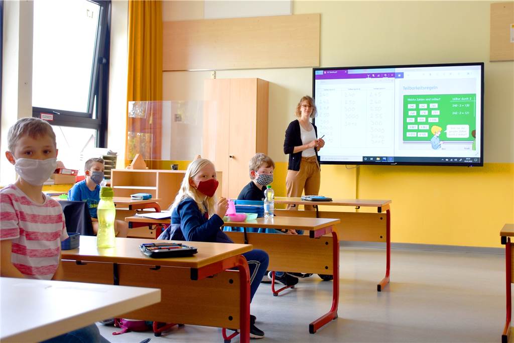 Grundschüler sind glücklich: Endlich wieder Schule und digitale Tafeln Die neuen digitalen Tafeln sind bei den Kindern der Renner. Auch wenn die Lehrer – wie hier Eva Elsner – noch mit einigen Kinderkrankheiten kämpfen müssen. Den Mundschutz müssen die Kinder normalerweise im Klassenraum nicht tragen, weil der Abstand zwischen den Tischen groß genug ist.