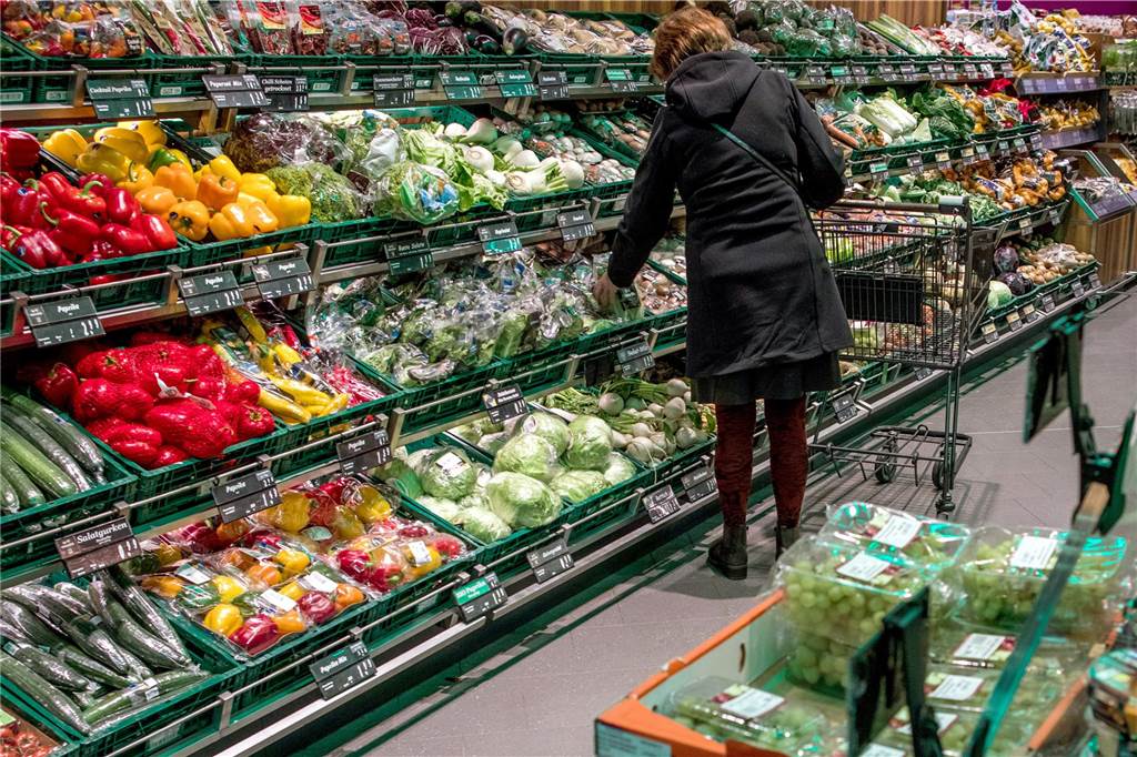 Lebensmittelspenden an die Tafel und die Steuer Eine Frau kauft im Supermarkt Gemüse ein.