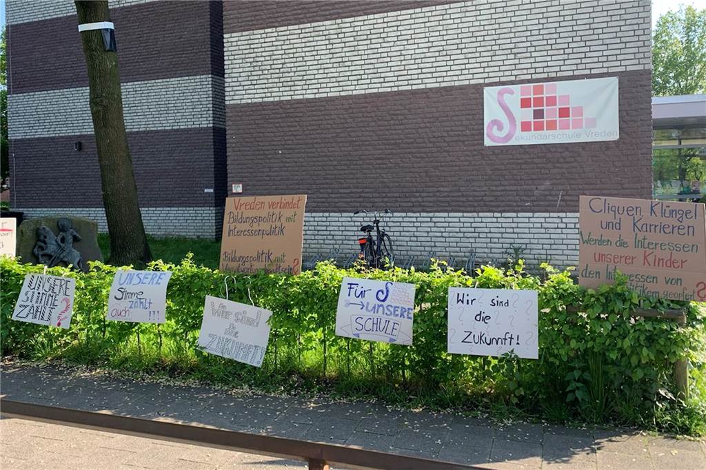 Zoff um Schulleiterstelle: Jetzt sind erste Entscheidungen gefallen Die Plakate der Schüler und Eltern durften nicht mit auf das Schulgelände des Gymnasiums. Darum standen sie vor der Sekundarschule.