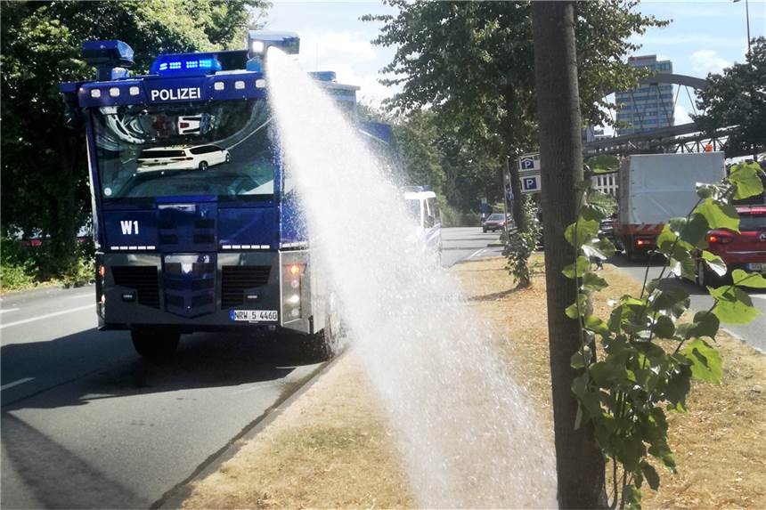Bis zu 39 Grad - NRW erwartet vorerst heißesten Tag des Jahres Die Polizei Wuppertal gießt die Bäume am Straßenrand mit Wasserwerfern.
