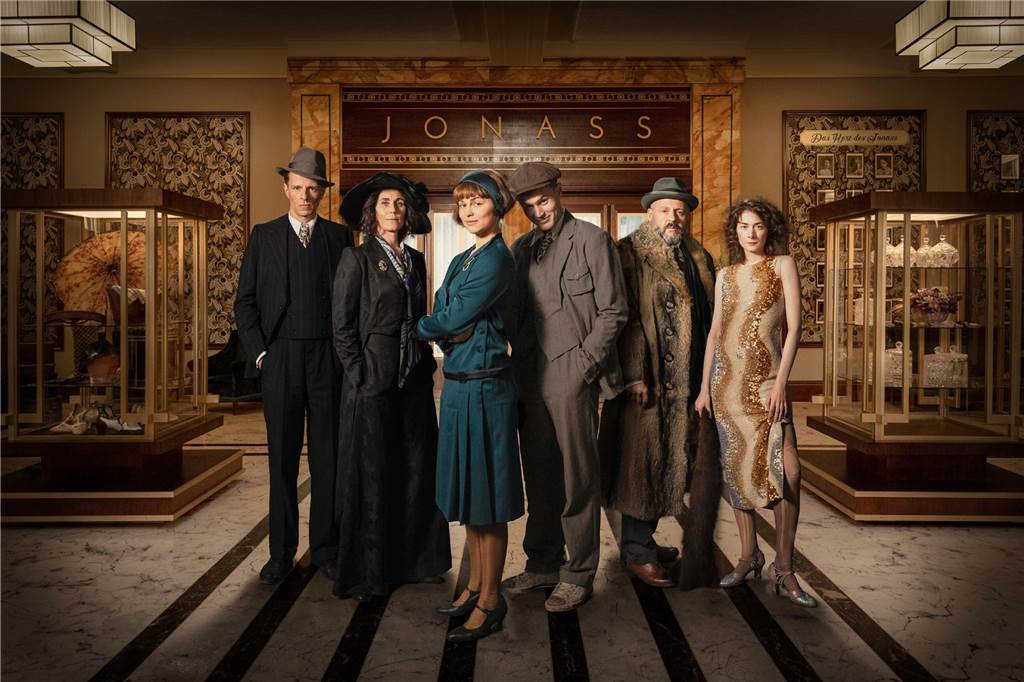 Arthur Grünberg (Alexander Scheer, l-r), Alice Grünberg (Nina Kunzendorf), Vicky Maler (Naemi Feitisch), Harry Grünberg (Ludwig Simon), Carl Goldmann (Samuel Finzi), Elsie Schön (Amy Benkenstein) stehen vor dem Kaufhaus "Jonass" (undatiert). 