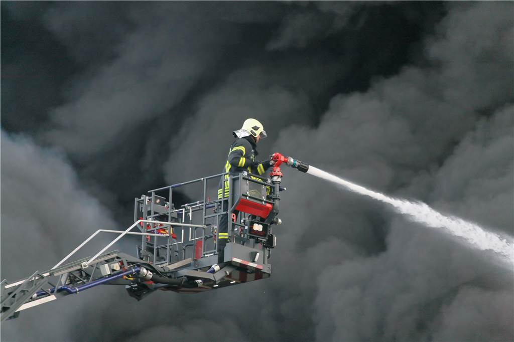 Das Feuer bei Wefapress - alle Informationen zusammengefasst Die Rauchsäule von dem Feuer war kilometerweit zu sehen. Im Bild steht der Korb der Drehleiter direkt vor der Wand aus Rauch und Ruß.