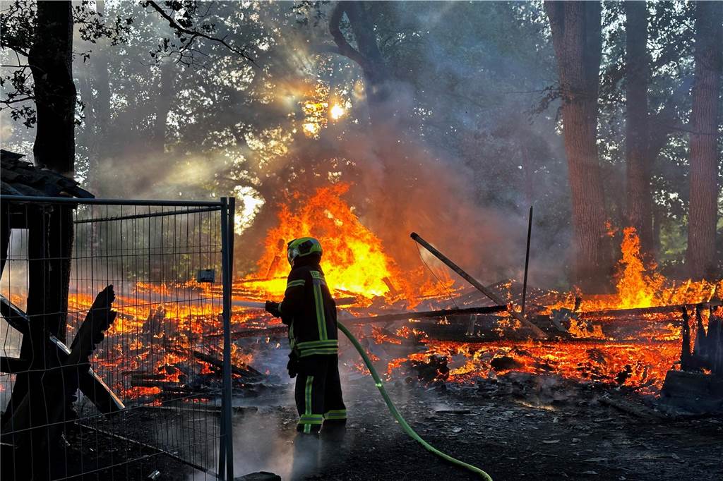 Ein Feuerwehrmann vor Flammen.