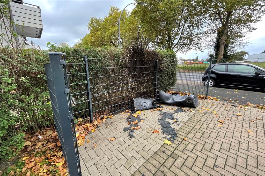 Vom Knistern der Flammen geweckt: So haben Anwohner die Mülltonnen-Brände erlebt Die Reste der verbrannten Mülltonnen liegen im Eingangsbereich eines Mehrfamilienhauses an der Wartburgstraße.