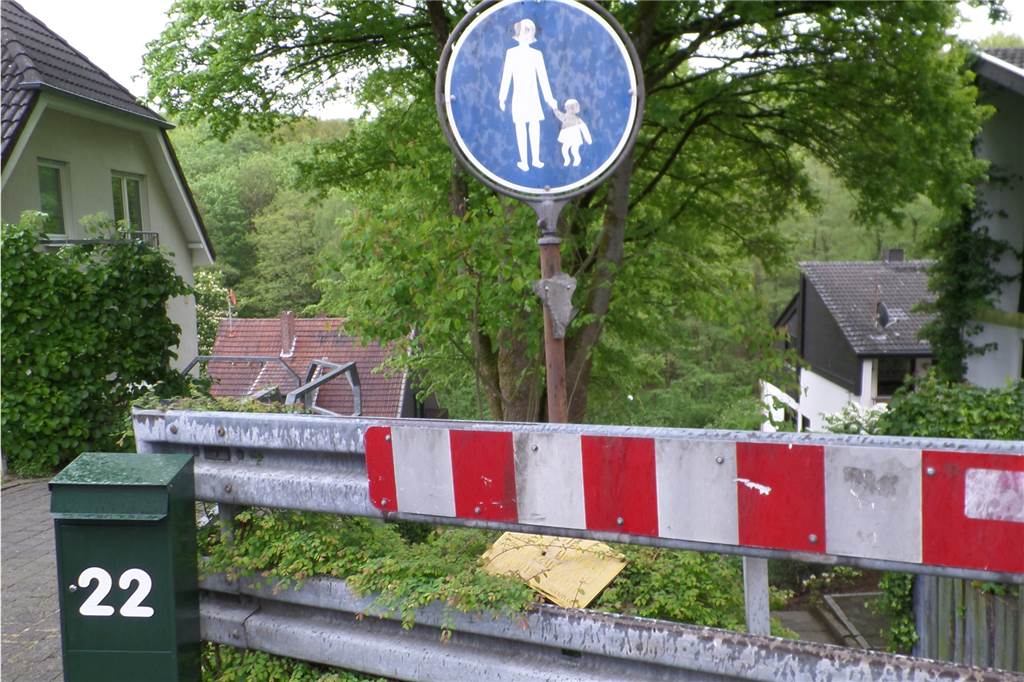 Die Schilder und Schutzplanken sind schon etwas älter. Die Mitteilung, dass im Winter nicht gestreut wird, liegt im Gebüsch.