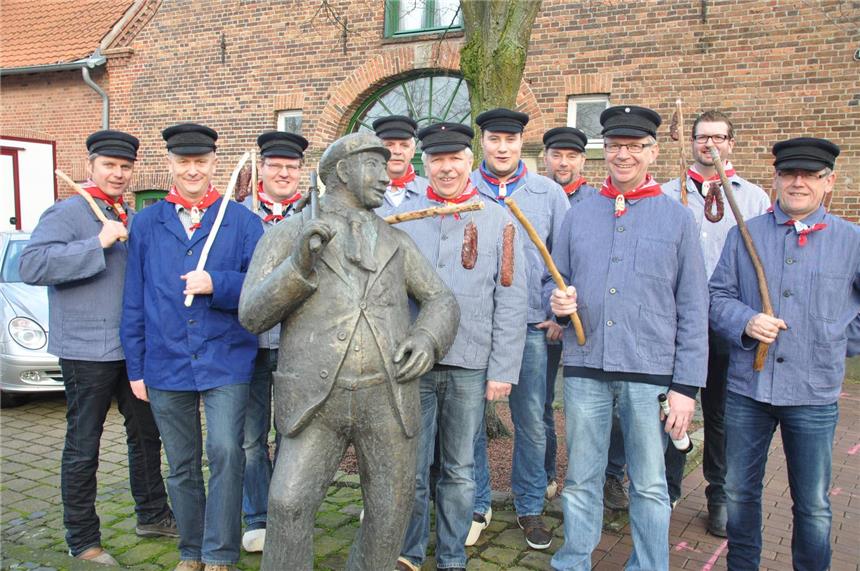 Es geht um die Wurst Die Schlöffkenkerls haben sich um die Statue gruppiert.