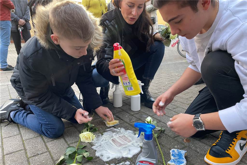 Zwei Schüler der Heinrich-Böll-Gesamtschule putzten mit ihrer Geschichtslehrerin Zeynep Gündogdu Stolpersteine in der Limbecker Straße in Lütgendortmund.