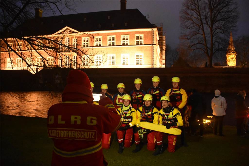 Gruppenbild der DLRG vor dem beleuchteten Schloss