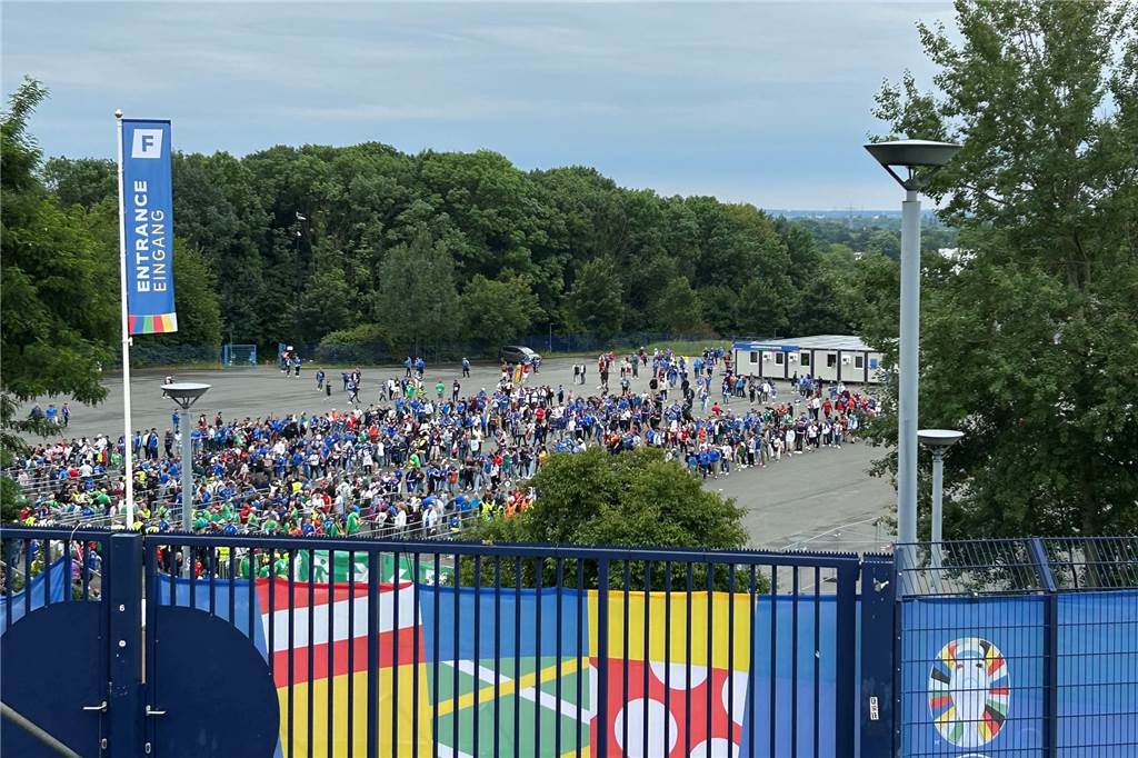 Der Welt-Star, die spanisch-italienische Liebe und das Risiko-Spiel Einige spanische und italienische Fans stehen auf dem Parkplatz P7 an der Arena Auf Schalke in der Schlange, um ins Stadion zu gehen.