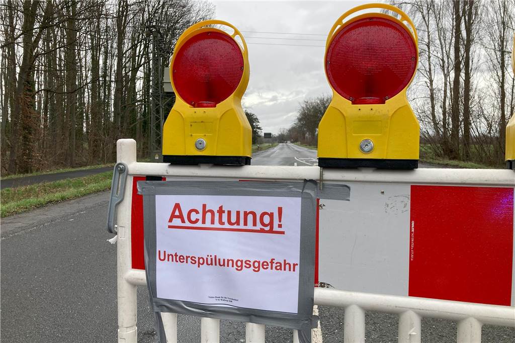 Borker Straße nicht mehr unter Wasser, aber weiterhin gesperrt Auf der Borker Straße in Waltrop stehen Absperrbaken. Auf einem Zettel darauf steht "Achtung! Unterspülungsgefahr".
