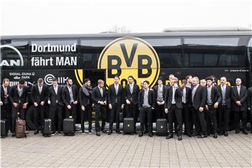 Die Spieler des BVB sammeln sich am Flughafen in Dortmund vor dem Abflug am Mannschaftsbus zu einem Gruppenfoto. Foto: Bernd Thissen