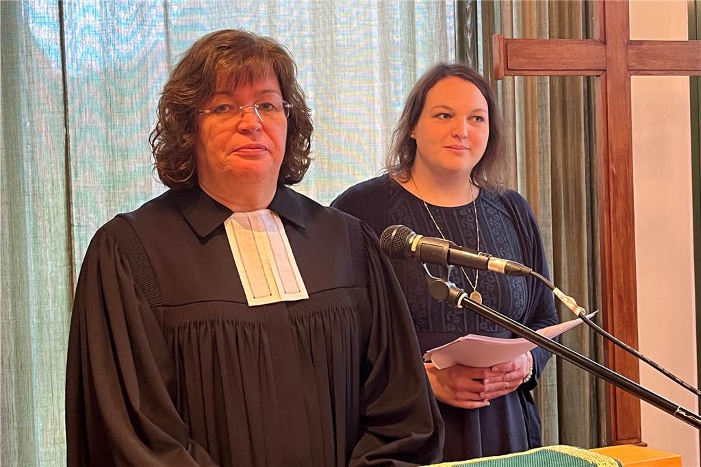 Ev. Kirche übergibt die Schlüssel ihres Gemeindezentrums in Flaesheim Pfarrerin im Ornat und eine weitere Frau an einem Rednerpult