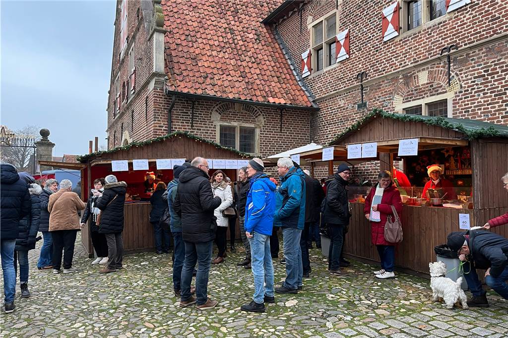 Besucherinnen und Besucher holen sich etwas zu Essen und zu Trinken.