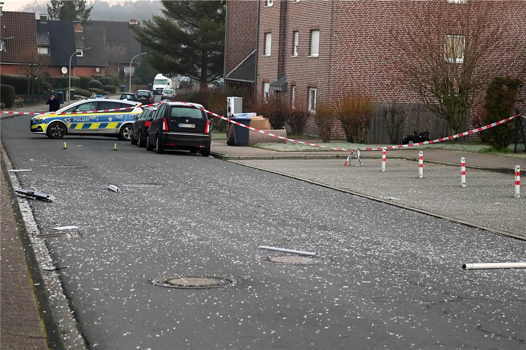 Zwei heftige Explosionen schrecken Anwohner auf: Geldautomat gesprengt Die Straße an der Volksbank-Filiale ist abgesperrt. Auch dort liegen Trümmerteile.